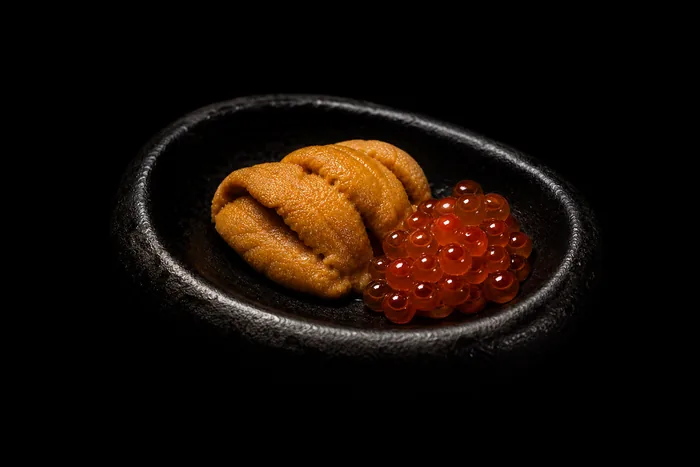Uni ikura sobre cuchara de porcelana negra