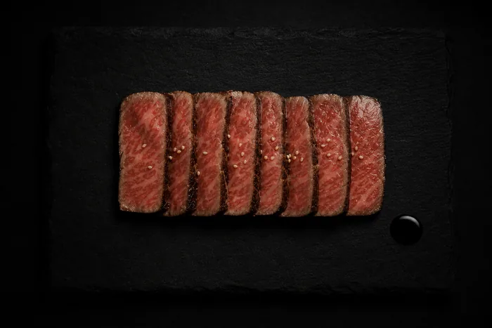 Wagyu tataki con reducción de ponzu sobre pizarra oscura